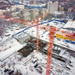 Construction Crane from Above. tower crane on the construction site aerial view. Aerial View Of construction site with crane. Construction workers are building. Top view